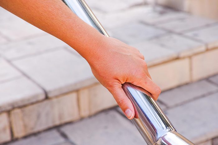 hand on an outdoor stair railing