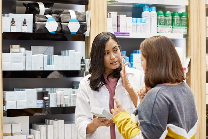 chemist explaining skin care product to customer