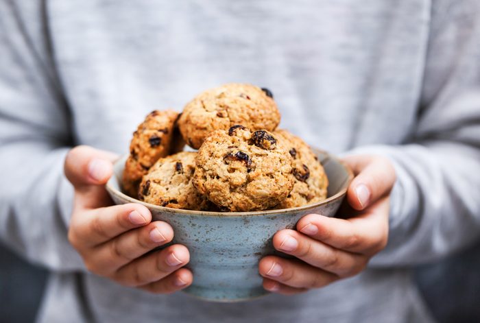 holding a bowl of fresh oatmeal cookies