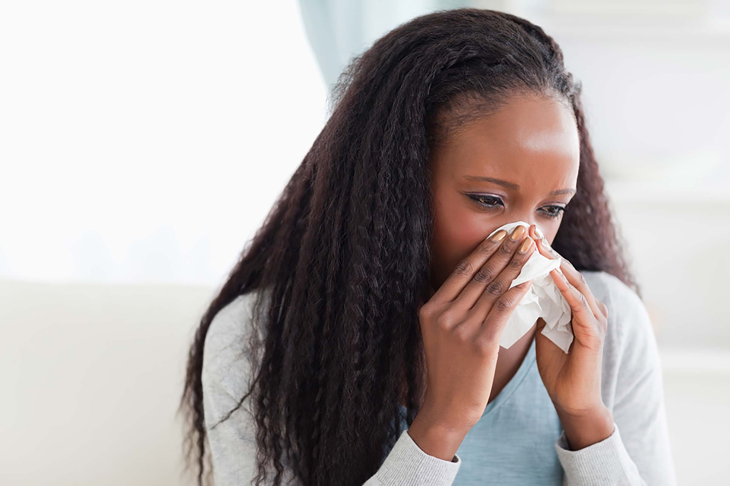 woman blowing her nose with a tissue