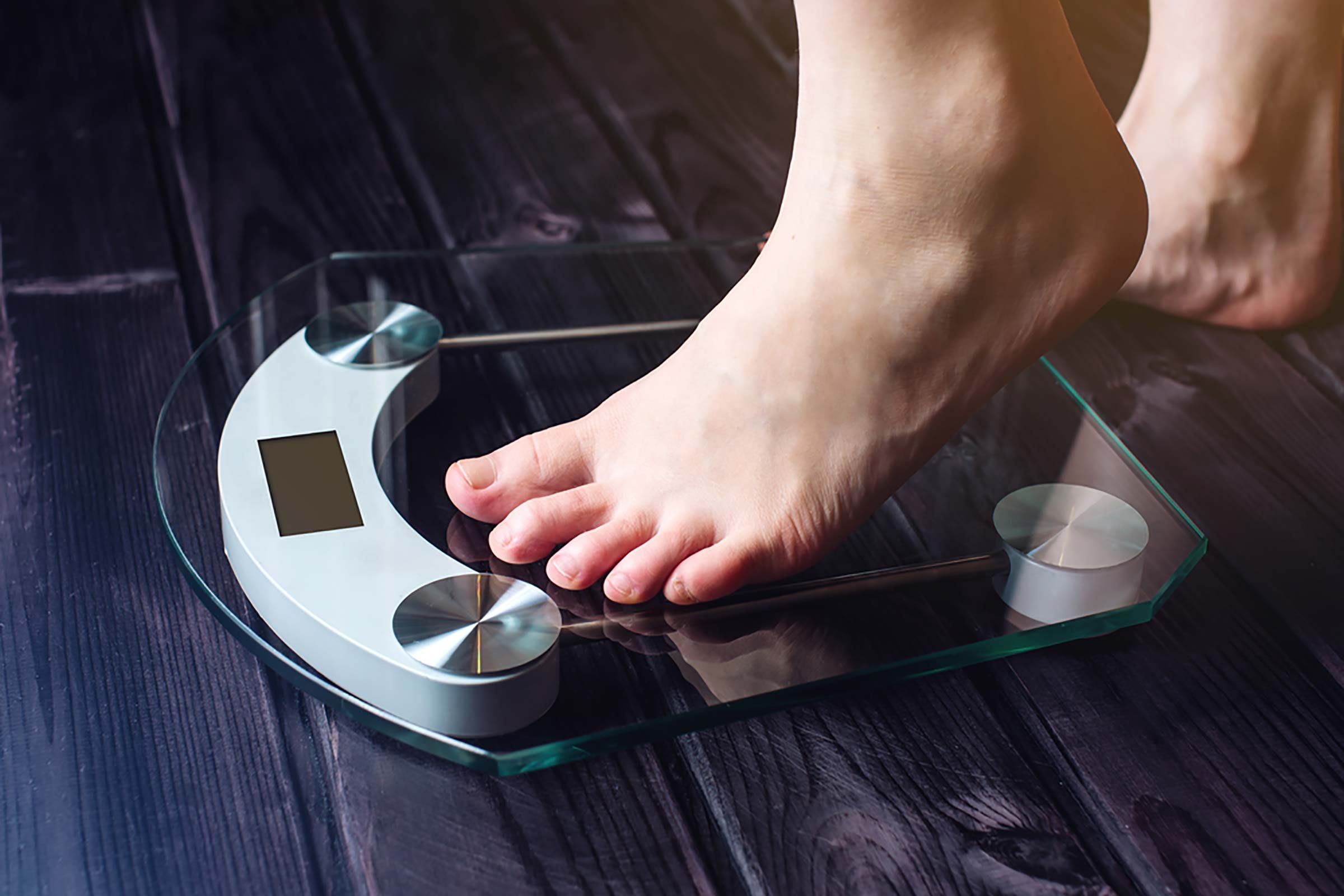 person stepping onto a digital scale