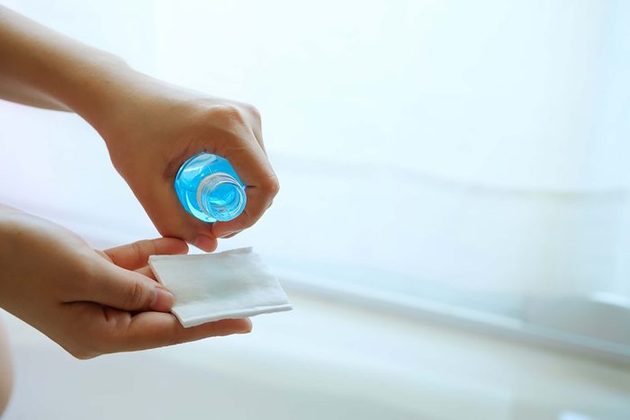 woman pouring rubbing Alcohol on a pad