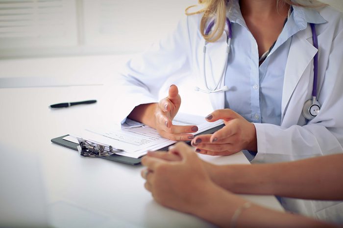Doctor with a clipboard speaking with a patient.