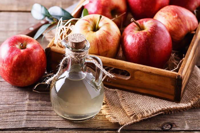 Tray with red apples next to container of vinegar