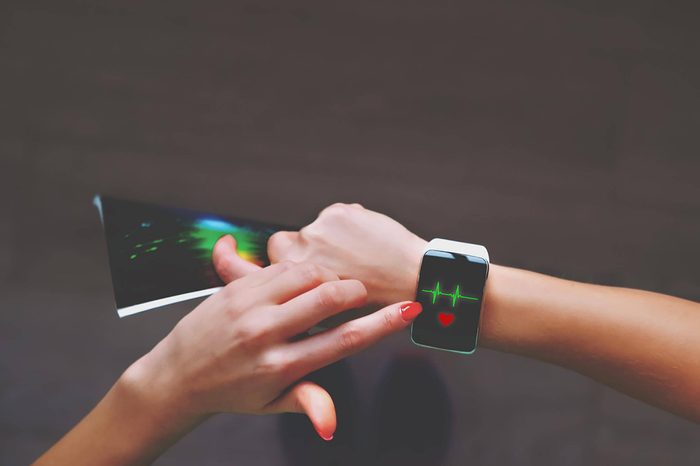 woman tapping her heart-rate monitor smart watch