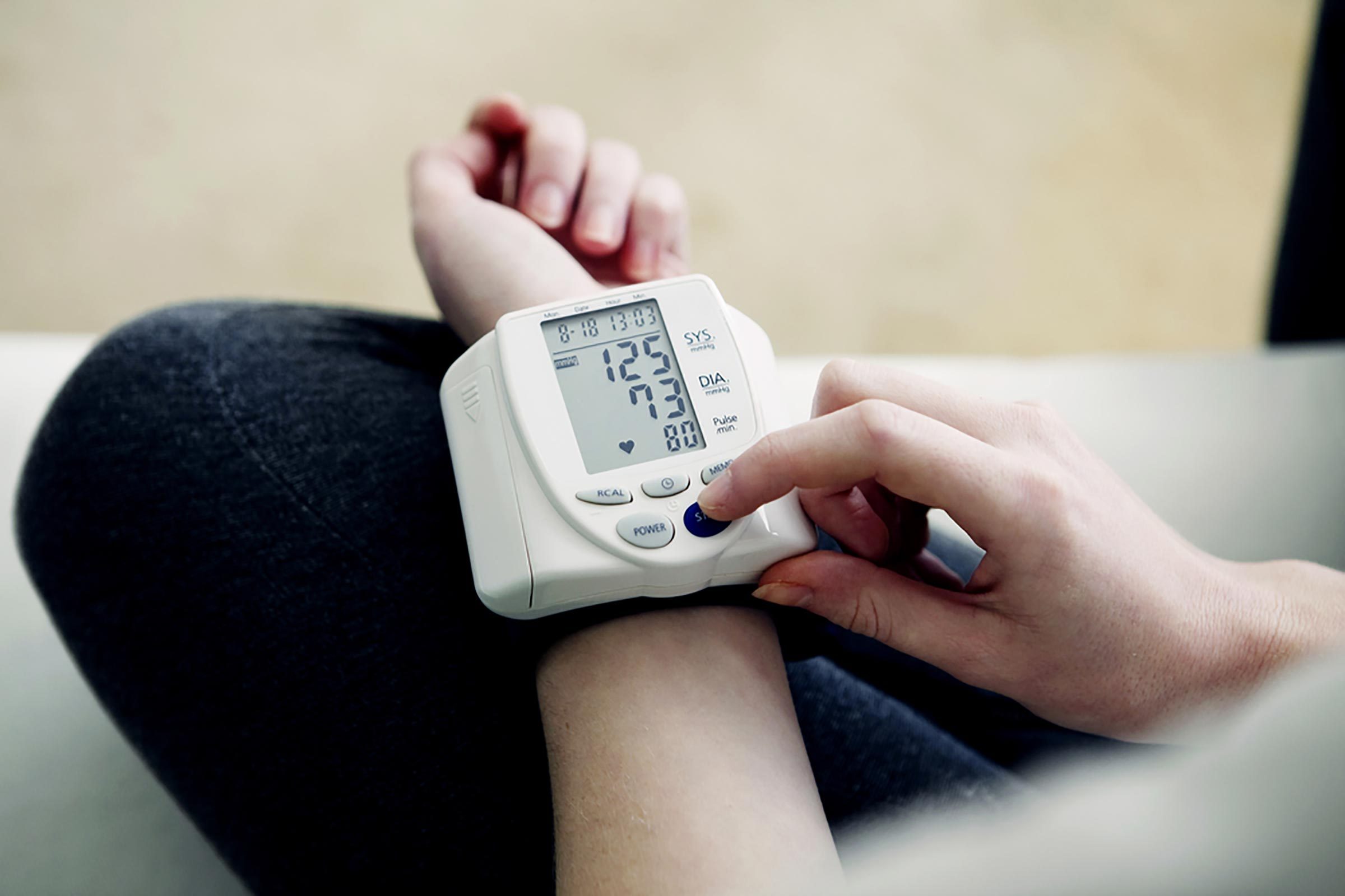 person checking blood pressure with wrist device