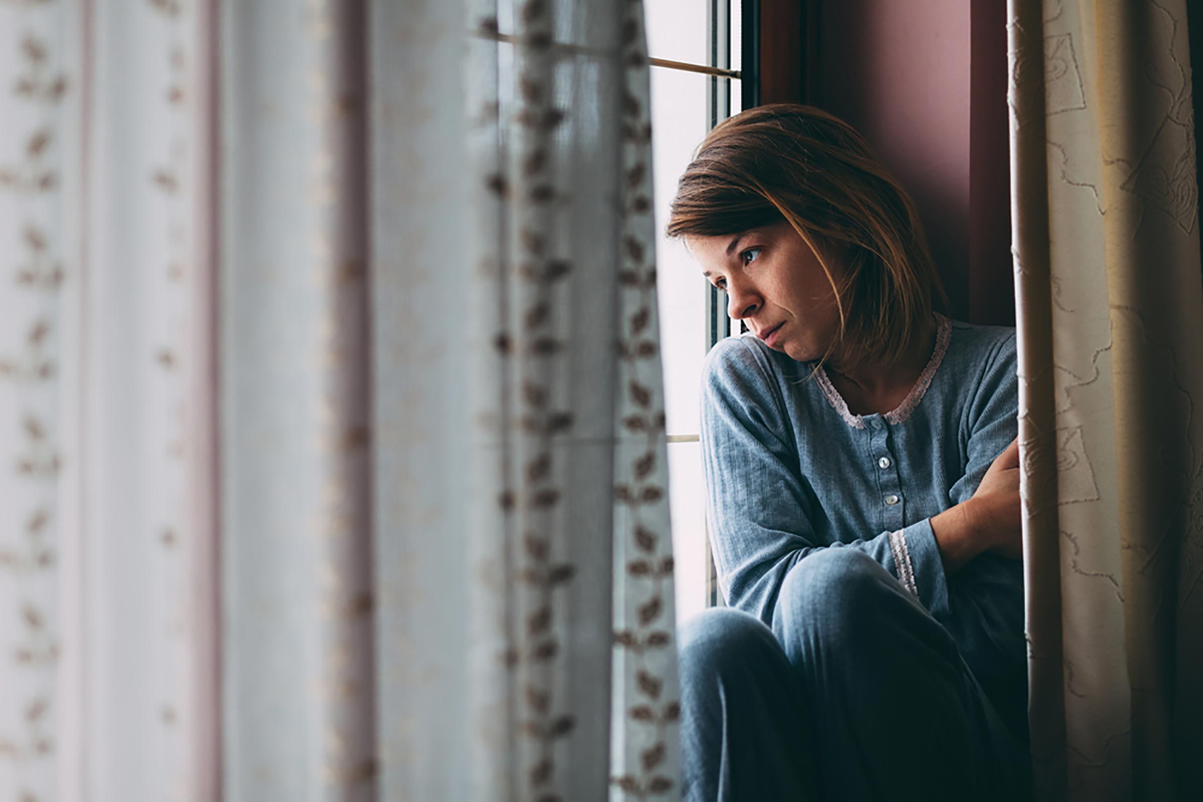 sad woman looking out a window