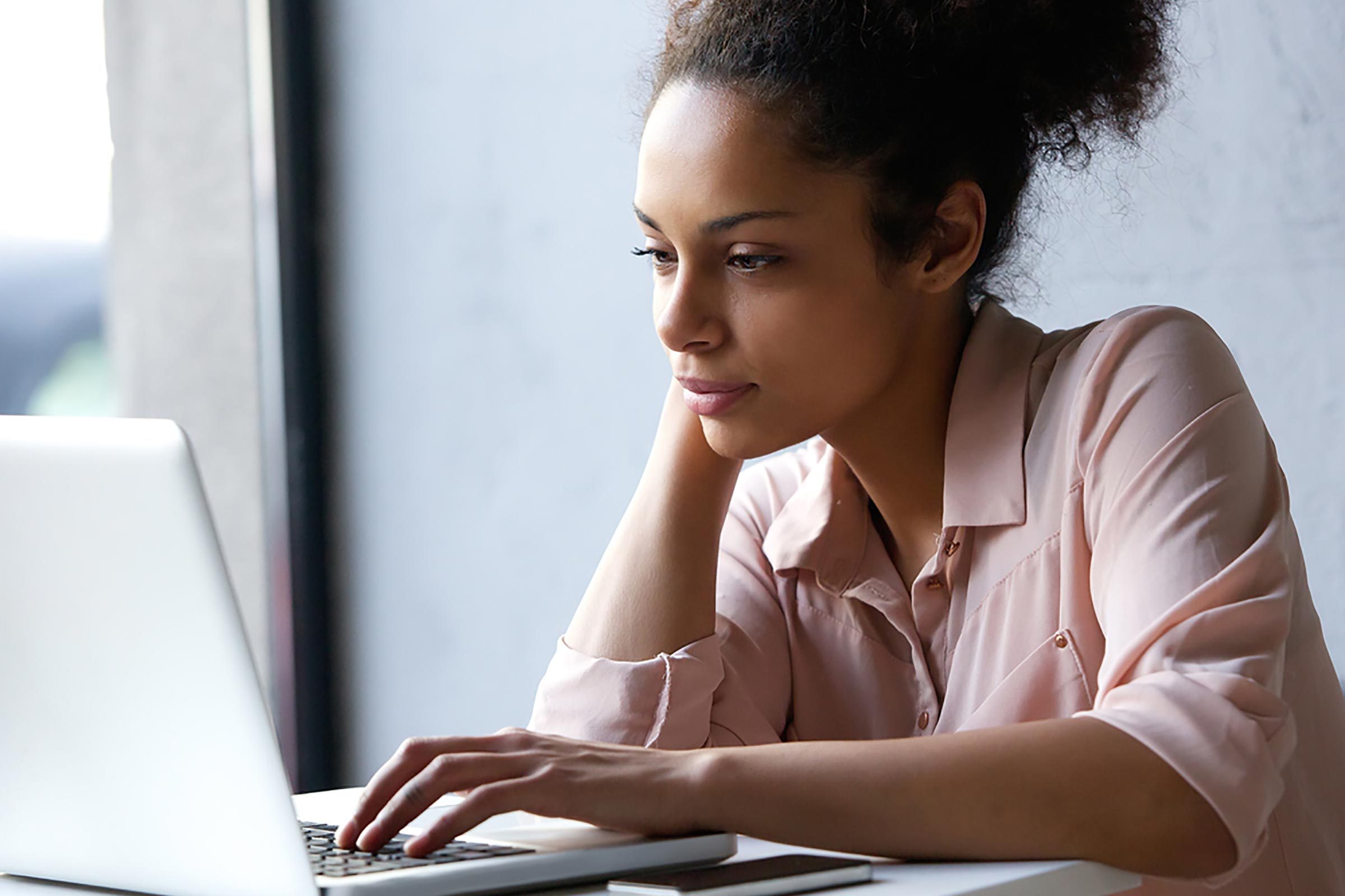 Black woman looking at a laptop computer