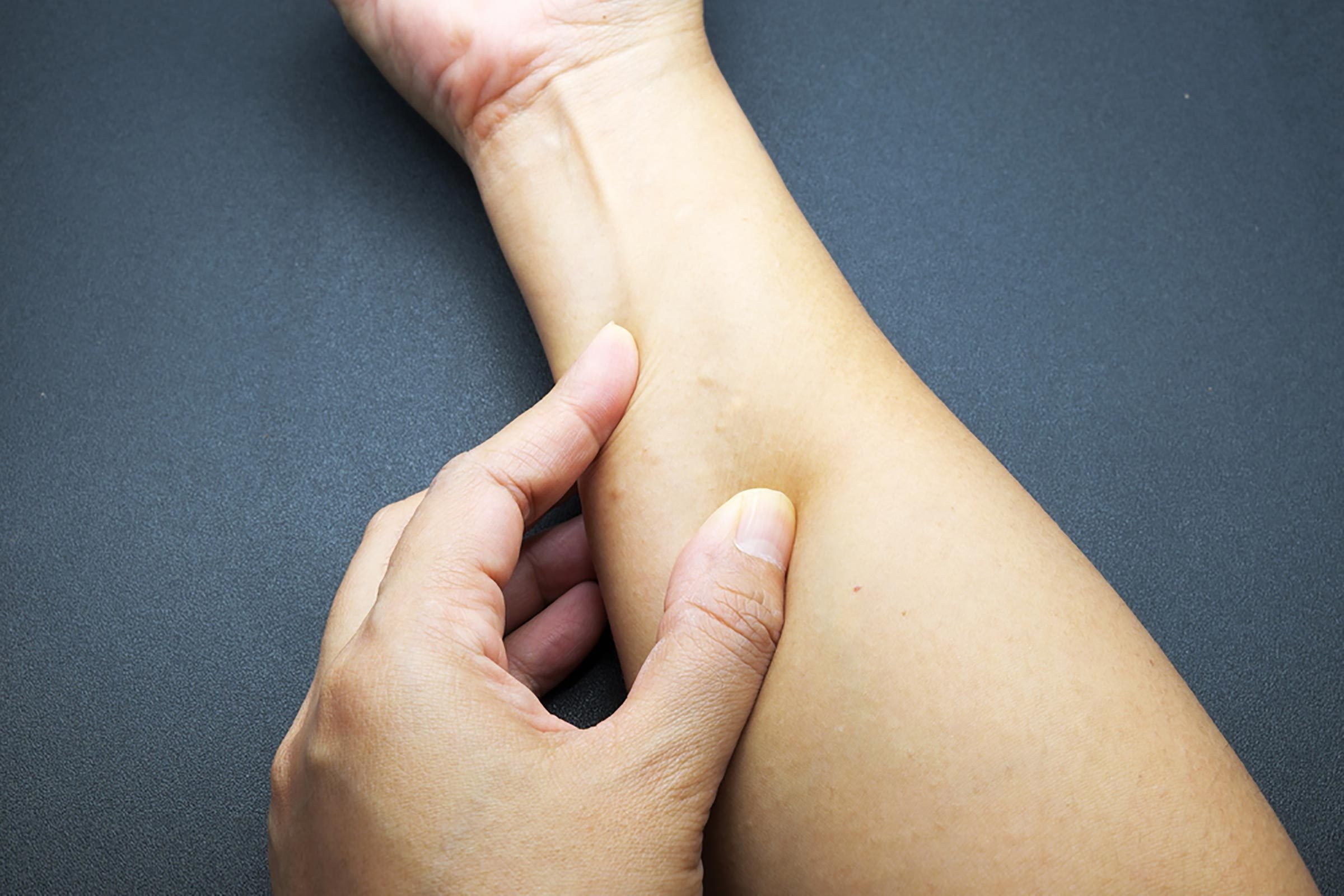 person examining their wrist with their other hand