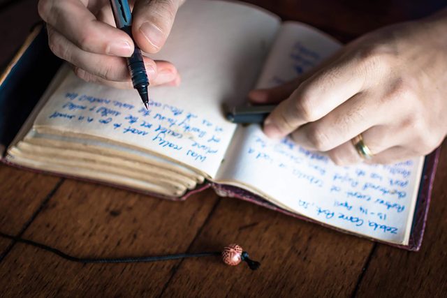 person writing in a journal