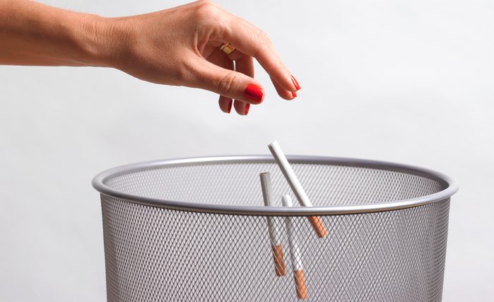 throwing cigarettes into garbage can