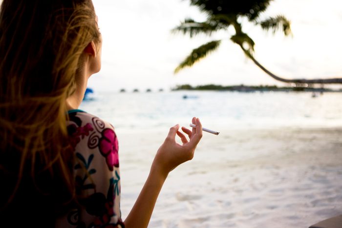 rear view of woman smoking on the beach