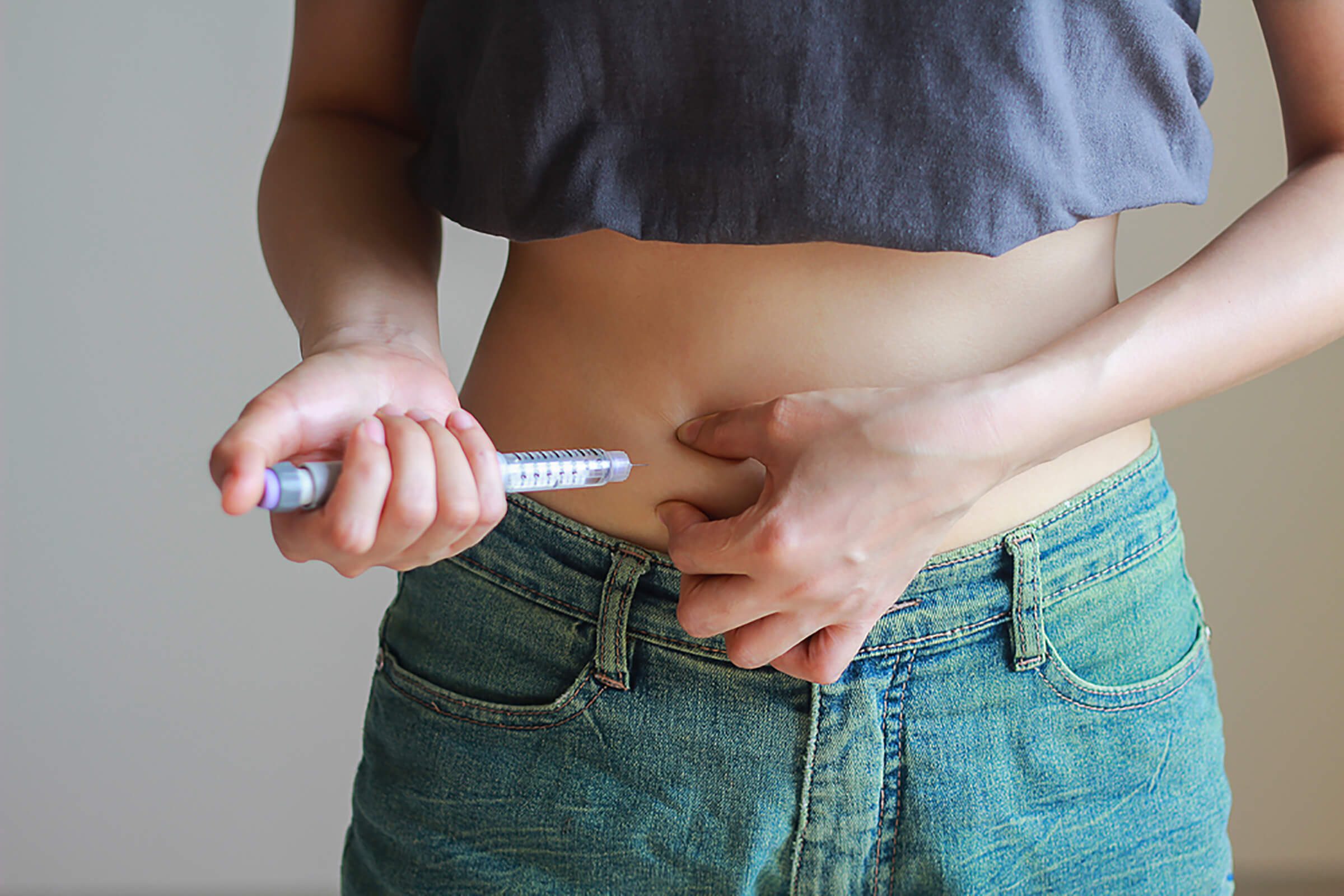 person giving insulin injection in stomach