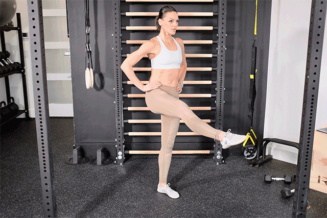 Woman doing standing leg lifts.