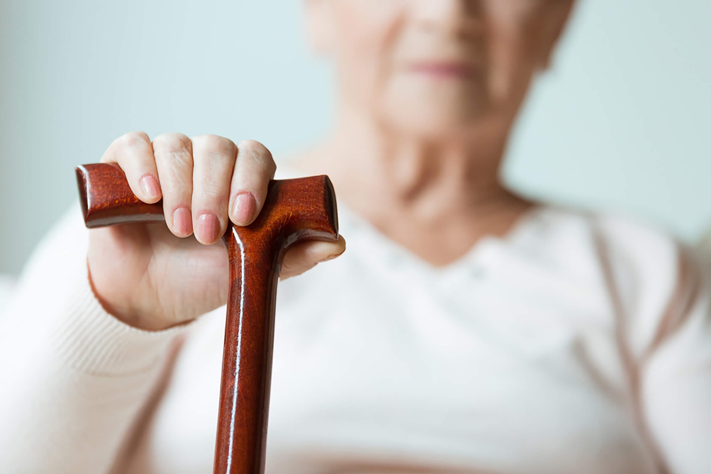 senior woman with hand on a cane