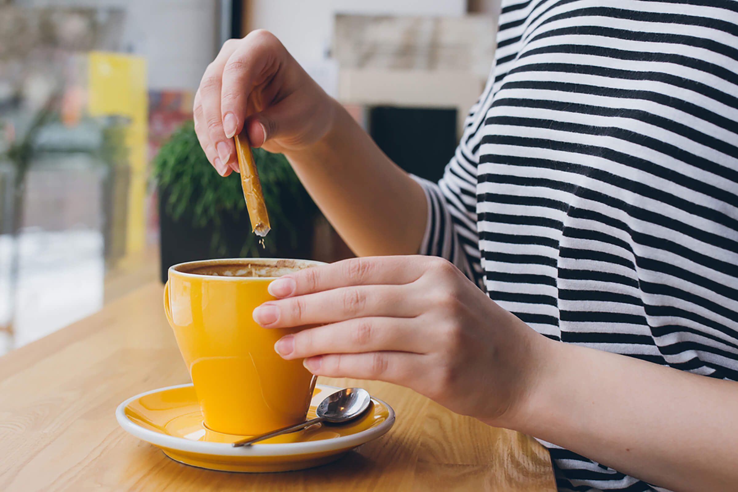 woman putting sweetener in cup