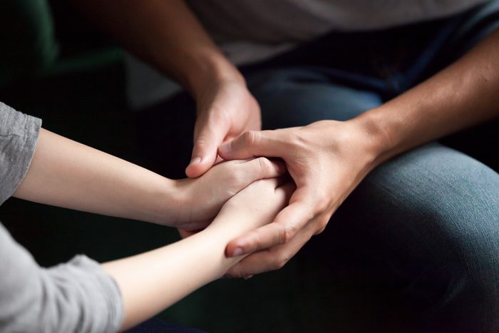 Close up view of couple holding hands, loving caring man supporting comforting woman, giving psychological support, help or protection, understanding in marriage relationships, reconciliation concept