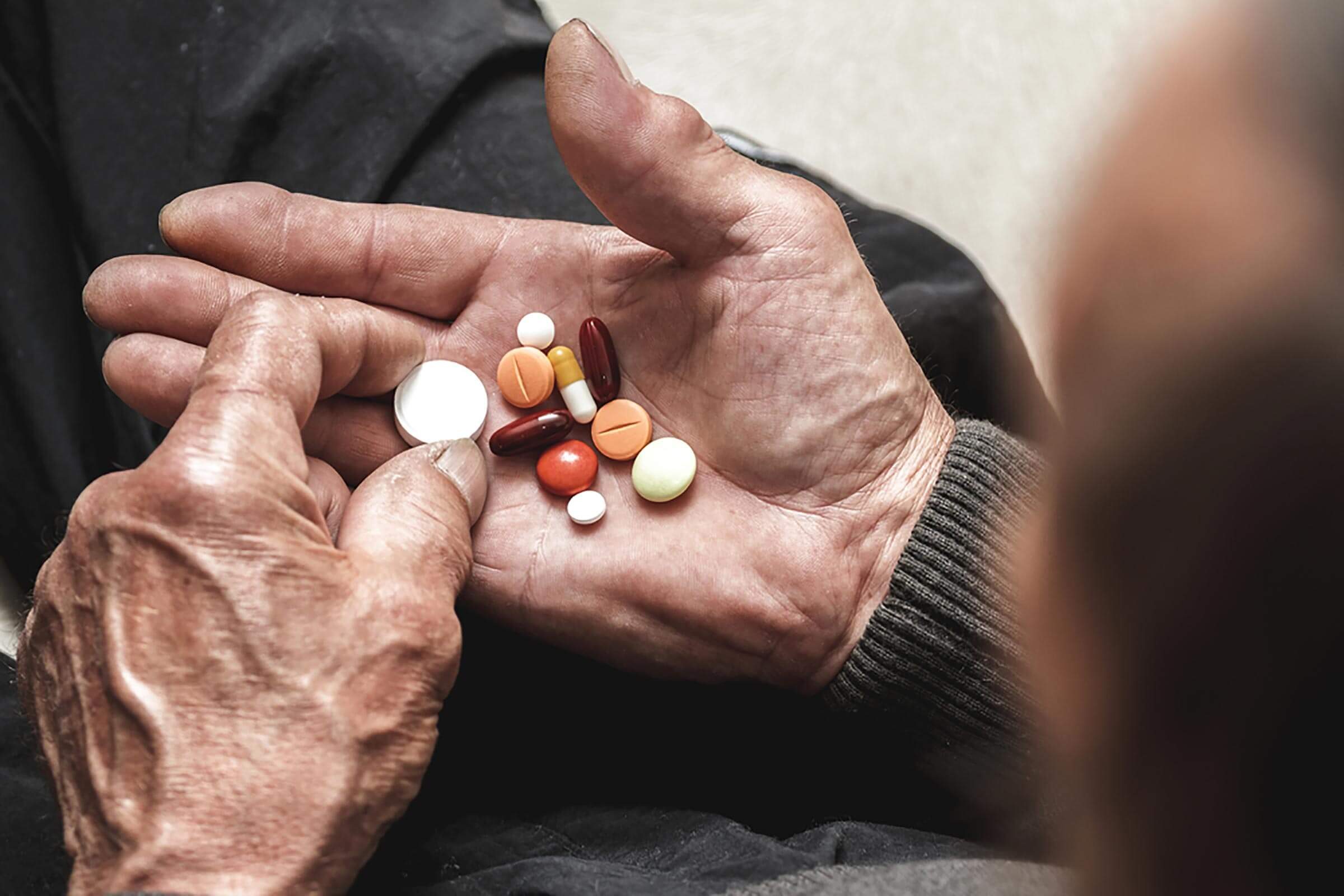 man with handful of medication