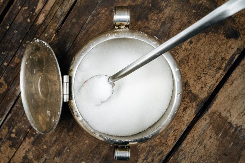 Macro close-up of a sugar bowl on old wooden table seen from above