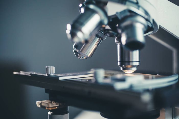 Close-up shot of microscope with metal lens at laboratory.