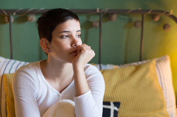 young woman sitting in bed not able to sleep