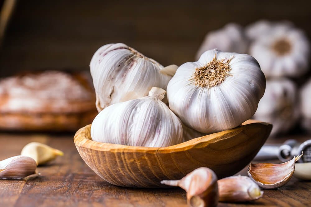 Garlic Cloves and Garlic Bulb in vintage wooden bowl.