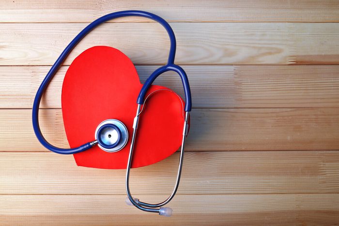 Stethoscope with heart on wooden background
