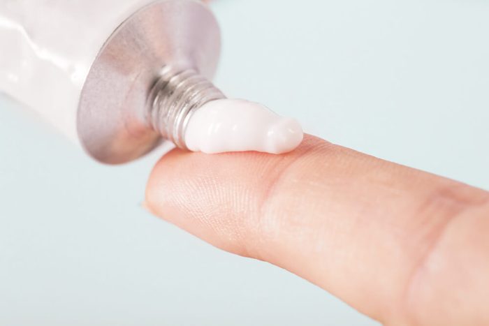 Close up image of hands with cream tube