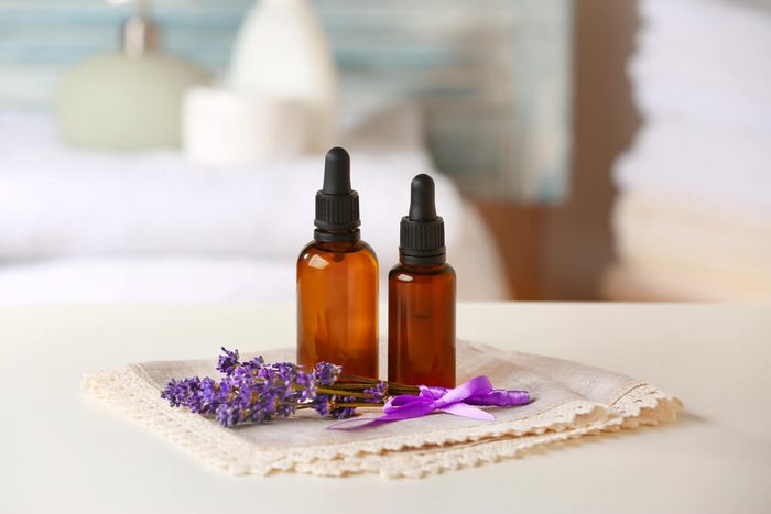 Bottles of essential oil with lavender on table