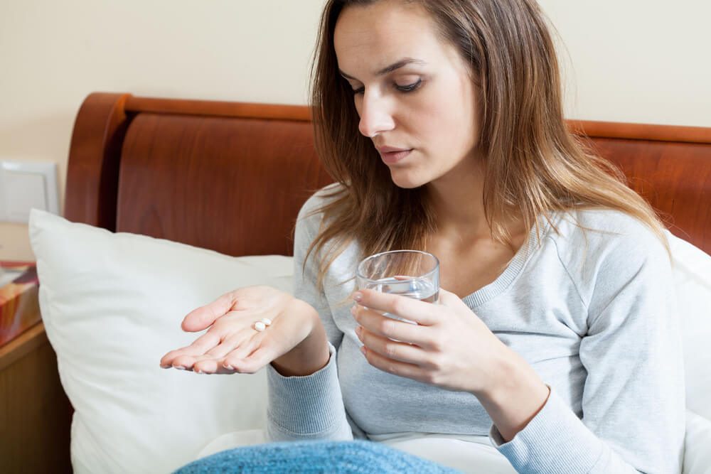 Horizontal view of taking pills for flu