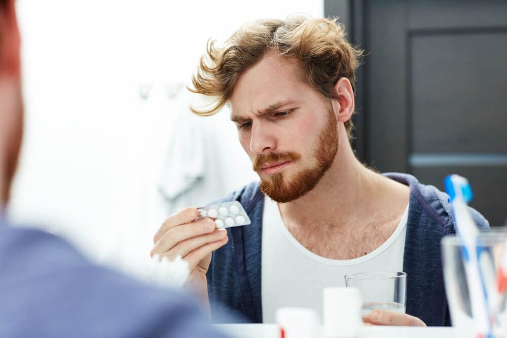 Man with headache going to take pill