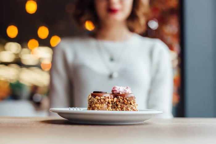 Delicious chocolate cake in shape of heart on wooden table in a cafe