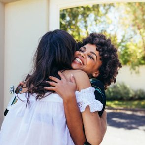 African woman greeting female friend for having a new house. Smiling young woman congratulating her friend. Couple welcoming friend for housewarming party.