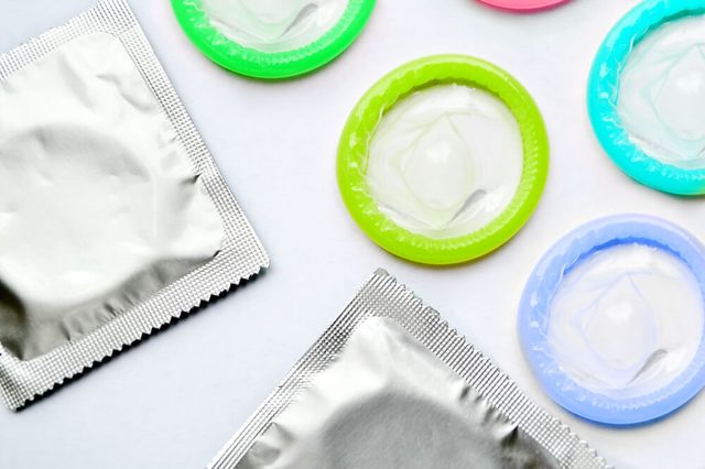 Couple of colorful condoms isolated on white