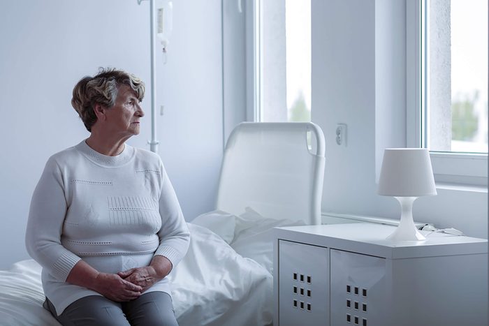 Elderly woman sitting on bed