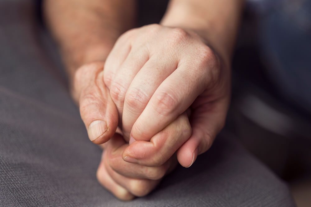 Old and young person holding hands. Elderly care and respect, selective focus