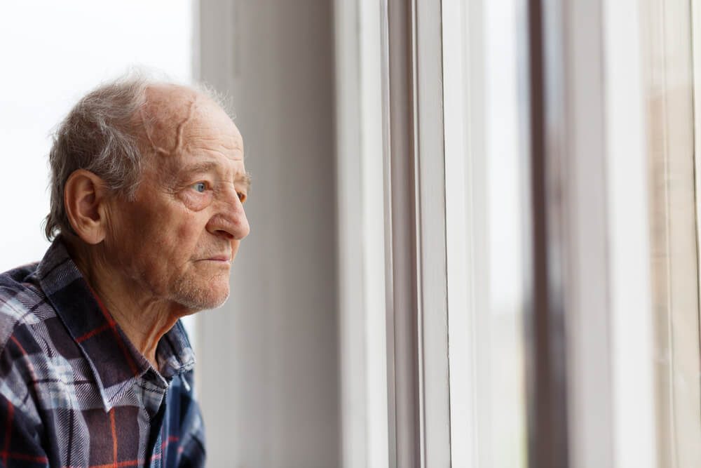 Portrait of Elderly man looking out window