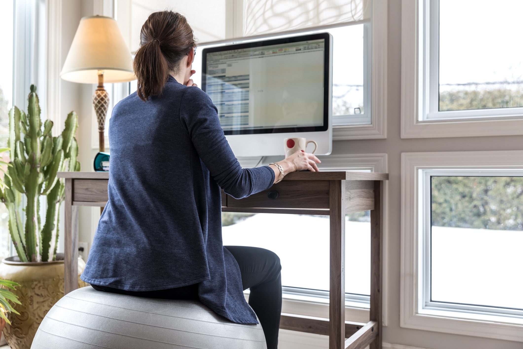 woman sitting on fitness ball at desk