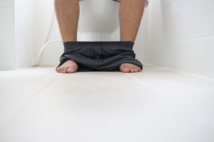 man sitting on toilet