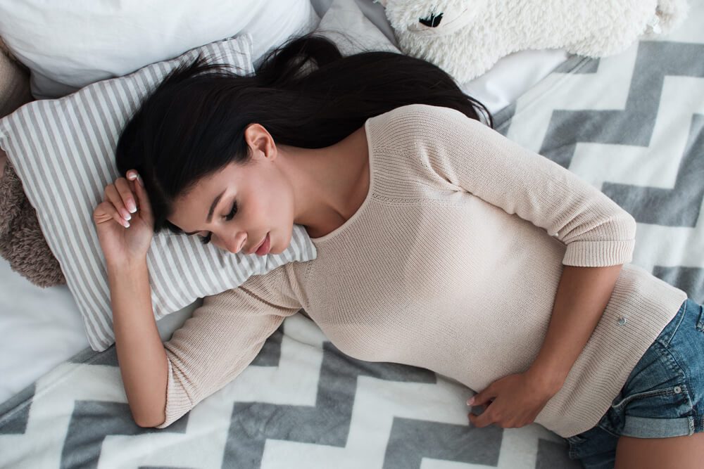 Little rest. Top view of beautiful young woman sleeping while lying down on her bed