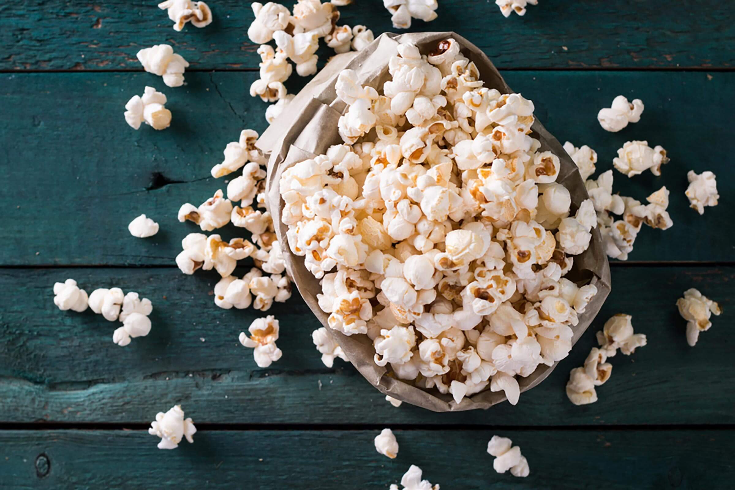 Salt popcorn on the wooden table, selective focus