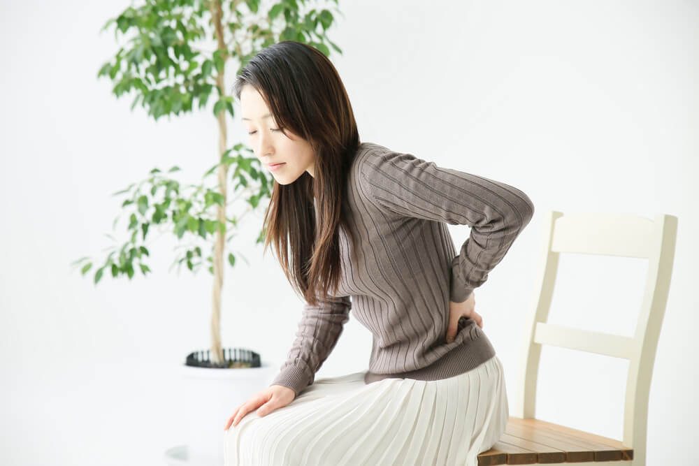 woman holding back pain