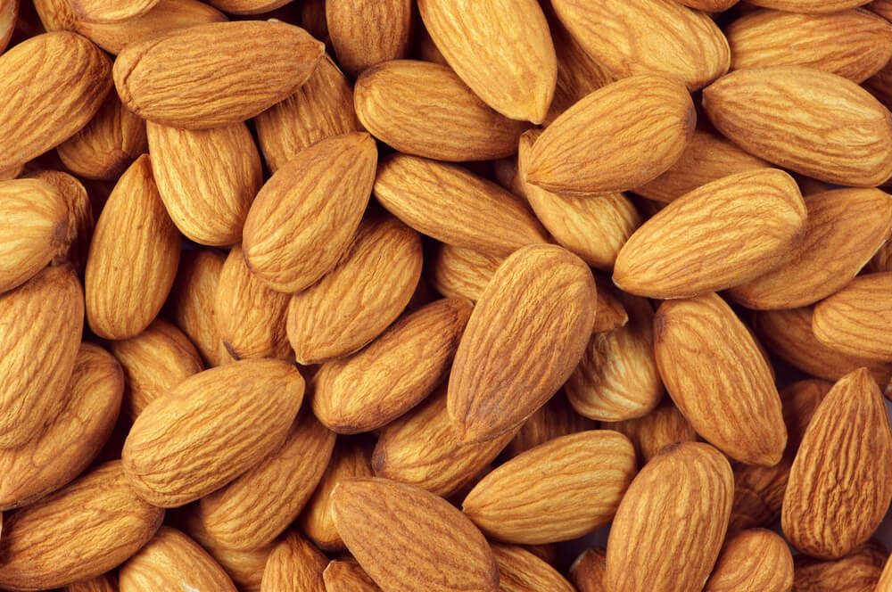 Pile of almonds close-up as background.