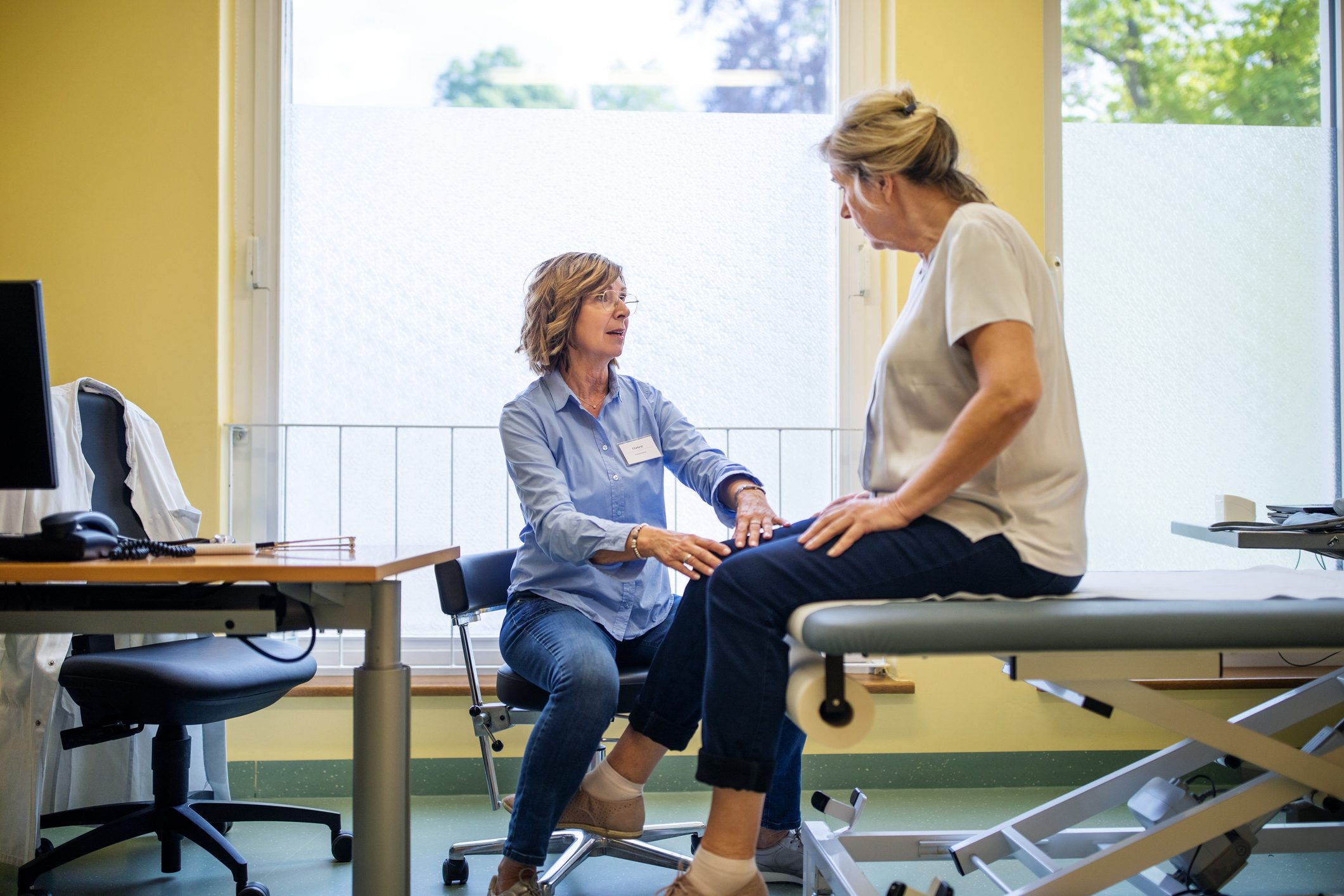 physical therapist checking patient's knee