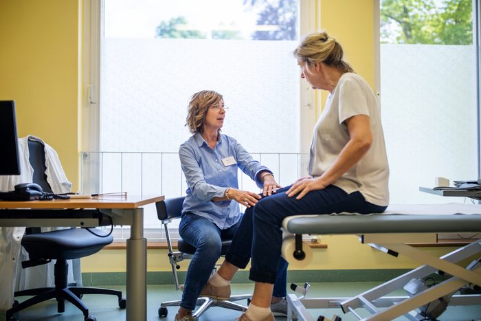 physical therapist checking patient's knee