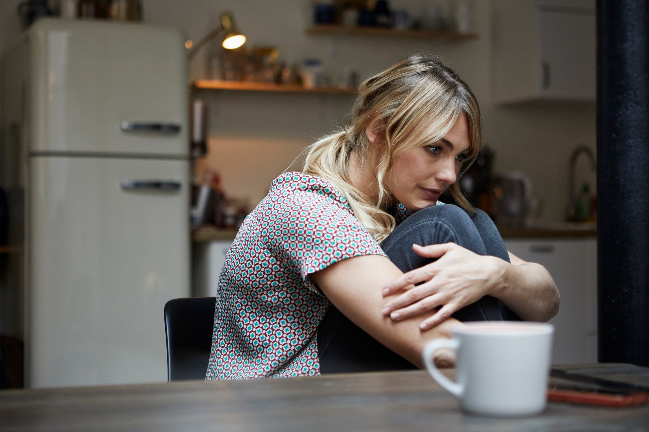 upset woman sitting at home alone