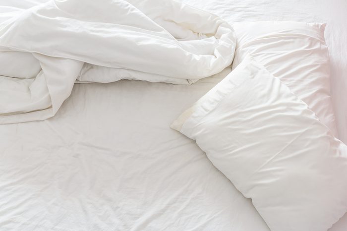 Top view of a messy bedroom with crumpled bedclothes. Bed room is not neatly arranged for new customers / guests to sleep in.