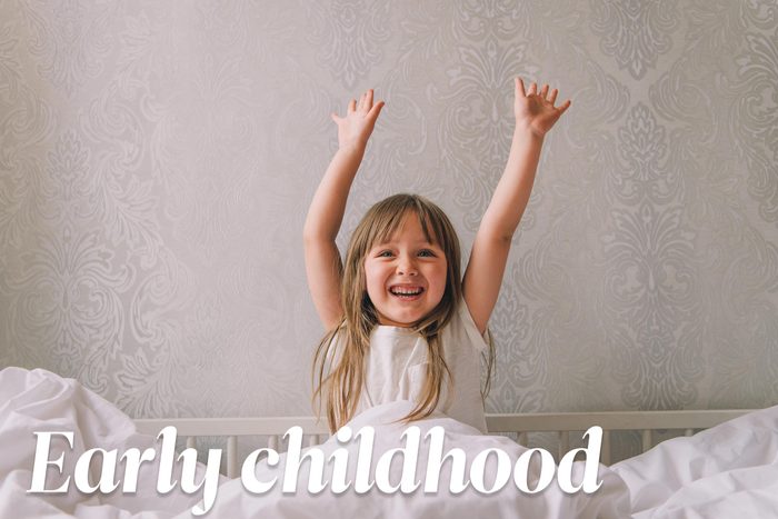 happy young girl with her hands up in the air