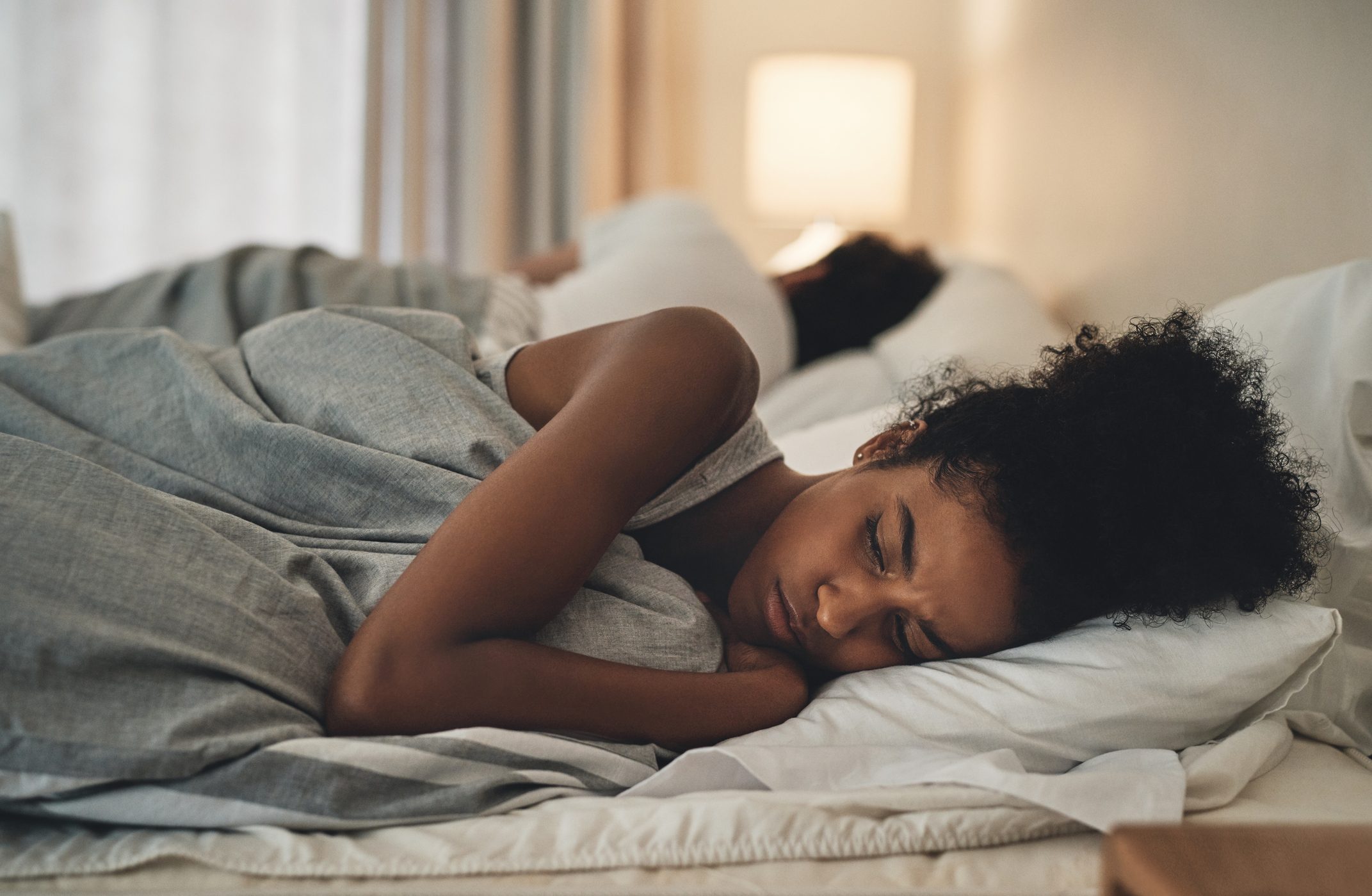 woman lying in bed next to husband