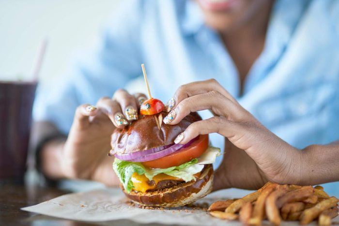 woman eating burger at restaurant